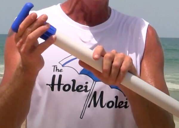 A man holding onto the end of a plastic tube.